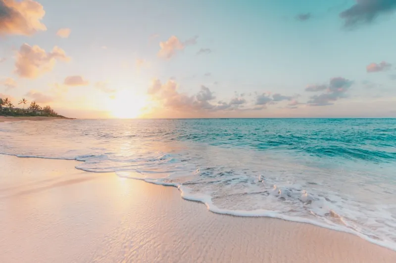 Ocean waves crashing on beach at dawn